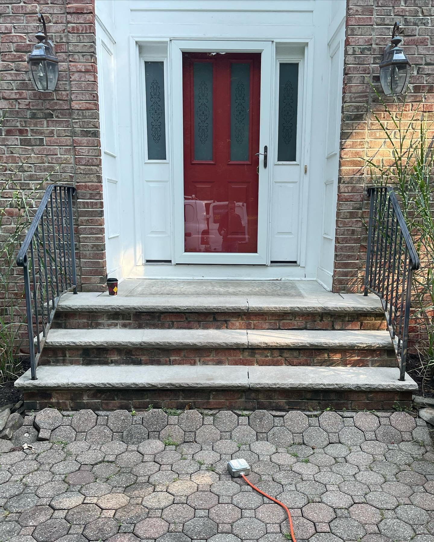 Before: the original front steps and black metal railings above the old patterned walkway.