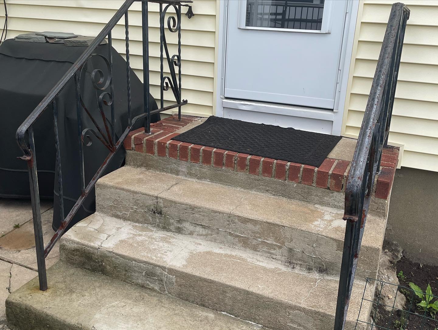 Before: cracked concrete steps, a brick-edged landing and weathered metal railings.