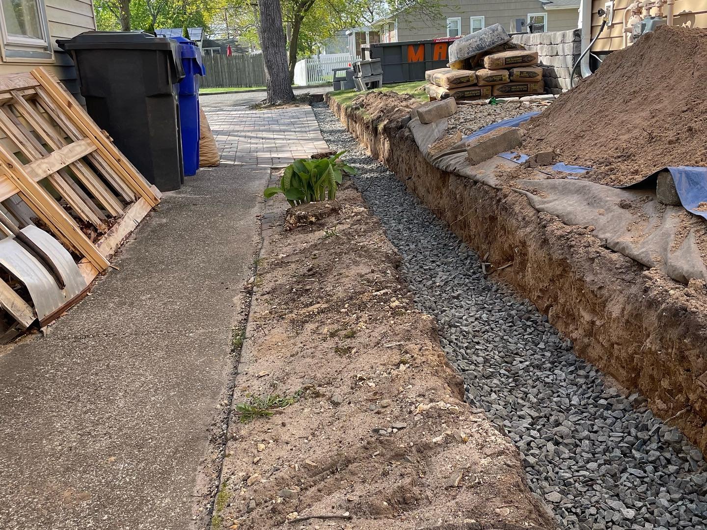 The crushed-stone base continuing through the side section between the house and the existing walking route.