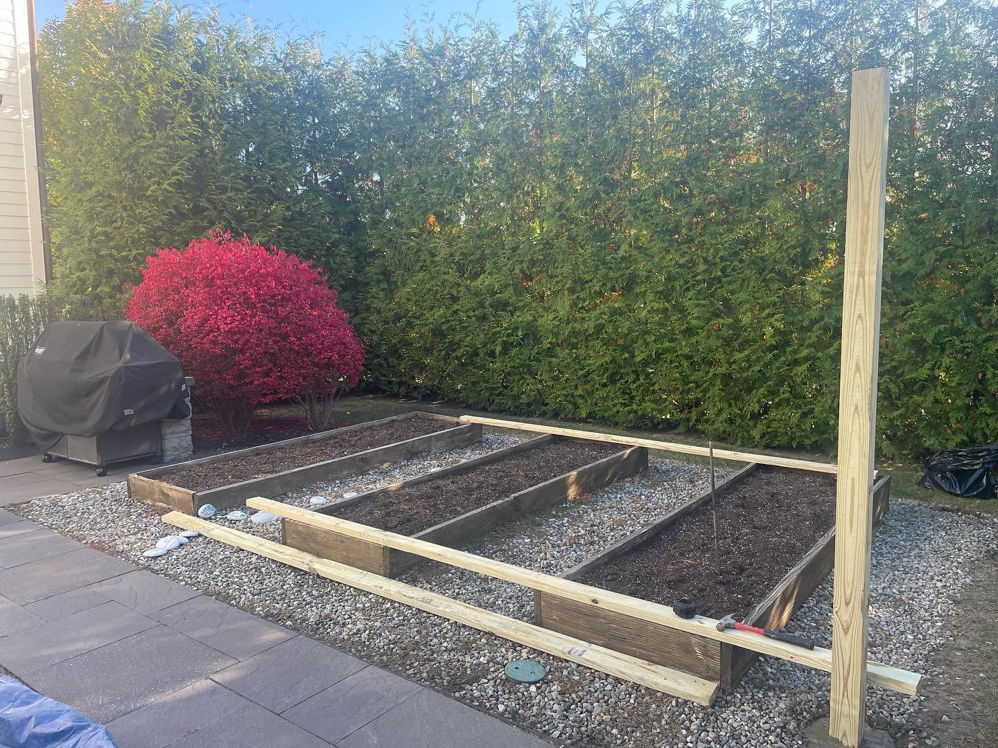 Early construction: the garden-bed layout with the first upright post visible at the corner.