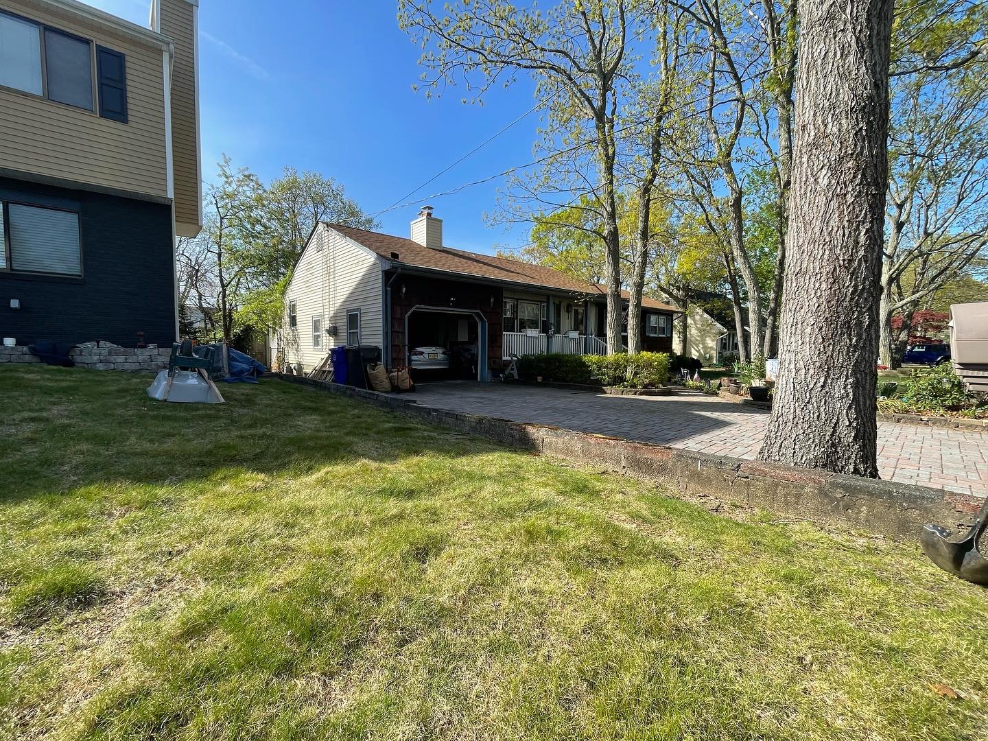 Before: the original concrete wall separating the front lawn from the paved approach beside the large tree.